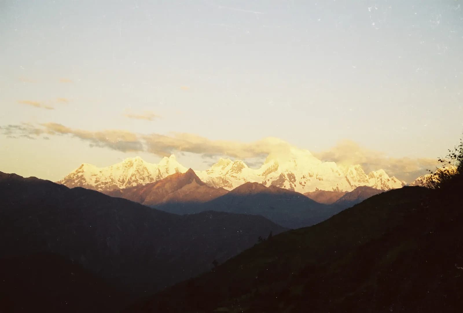 Las caras oeste de la Cordillera Huayhuash encendidas por la última luz de la tarde, sobre valles ya en sombra.