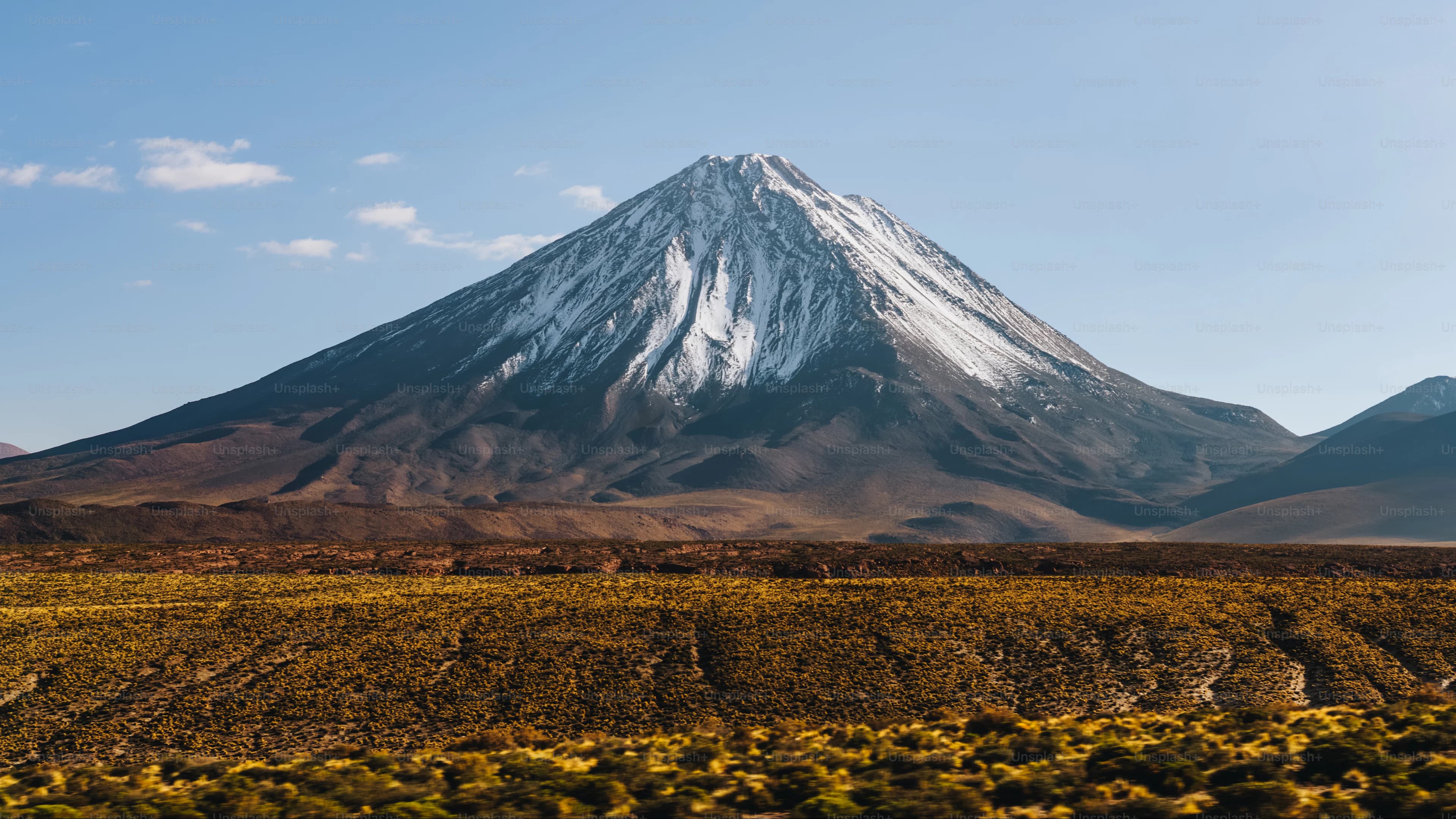 A snow-capped mountain above a dry plateau; representative route imagery.