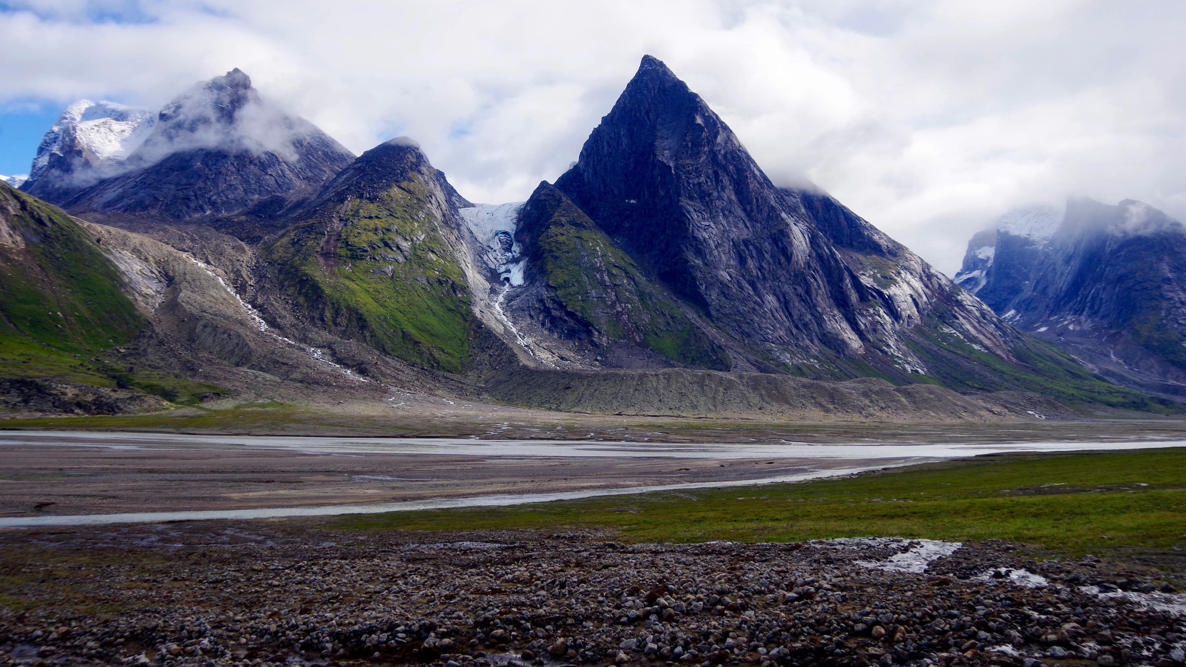Steep rock and snow above a remote valley; representative route imagery.