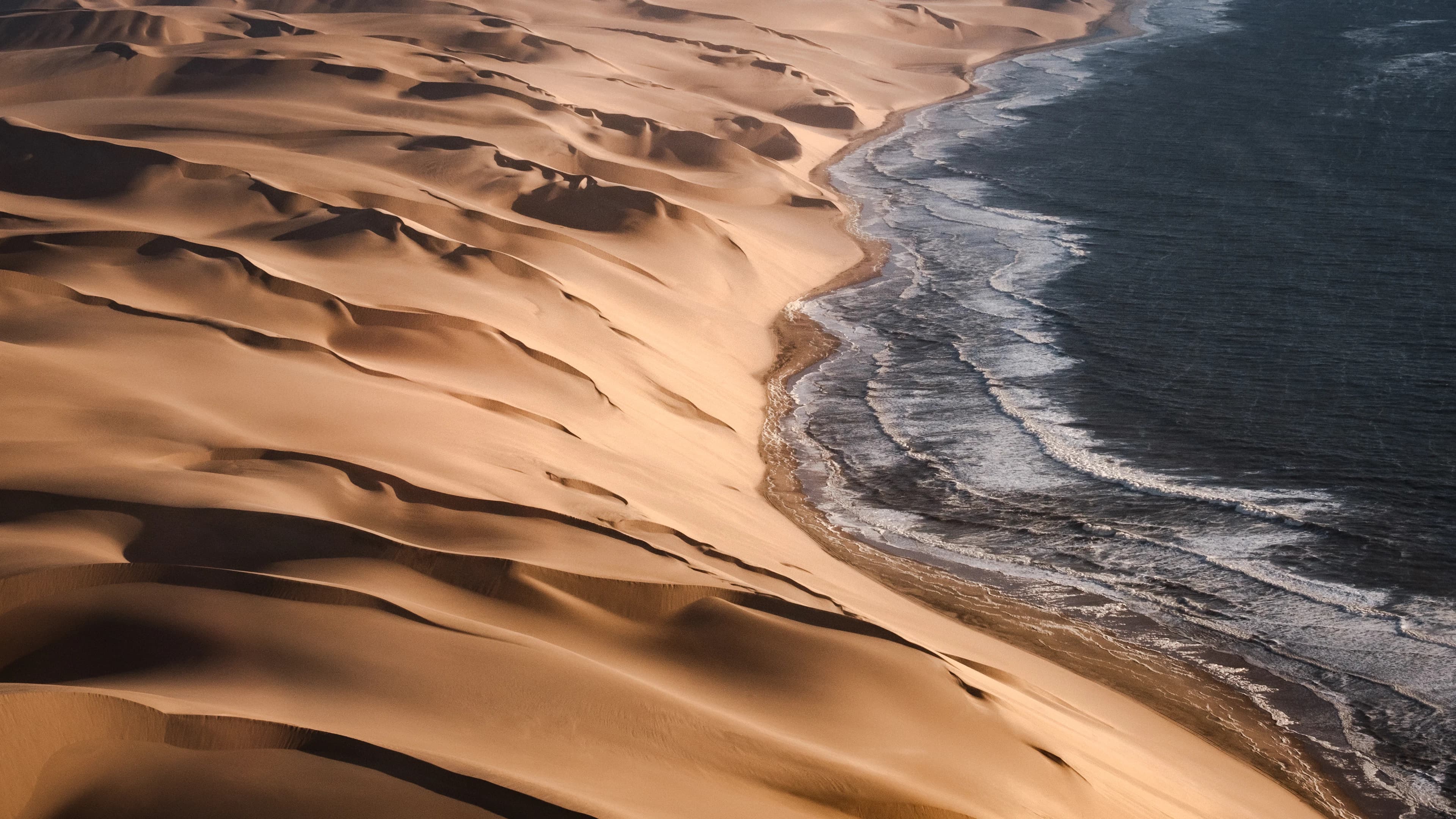 Sand meeting ocean surf; representative coastal route imagery.