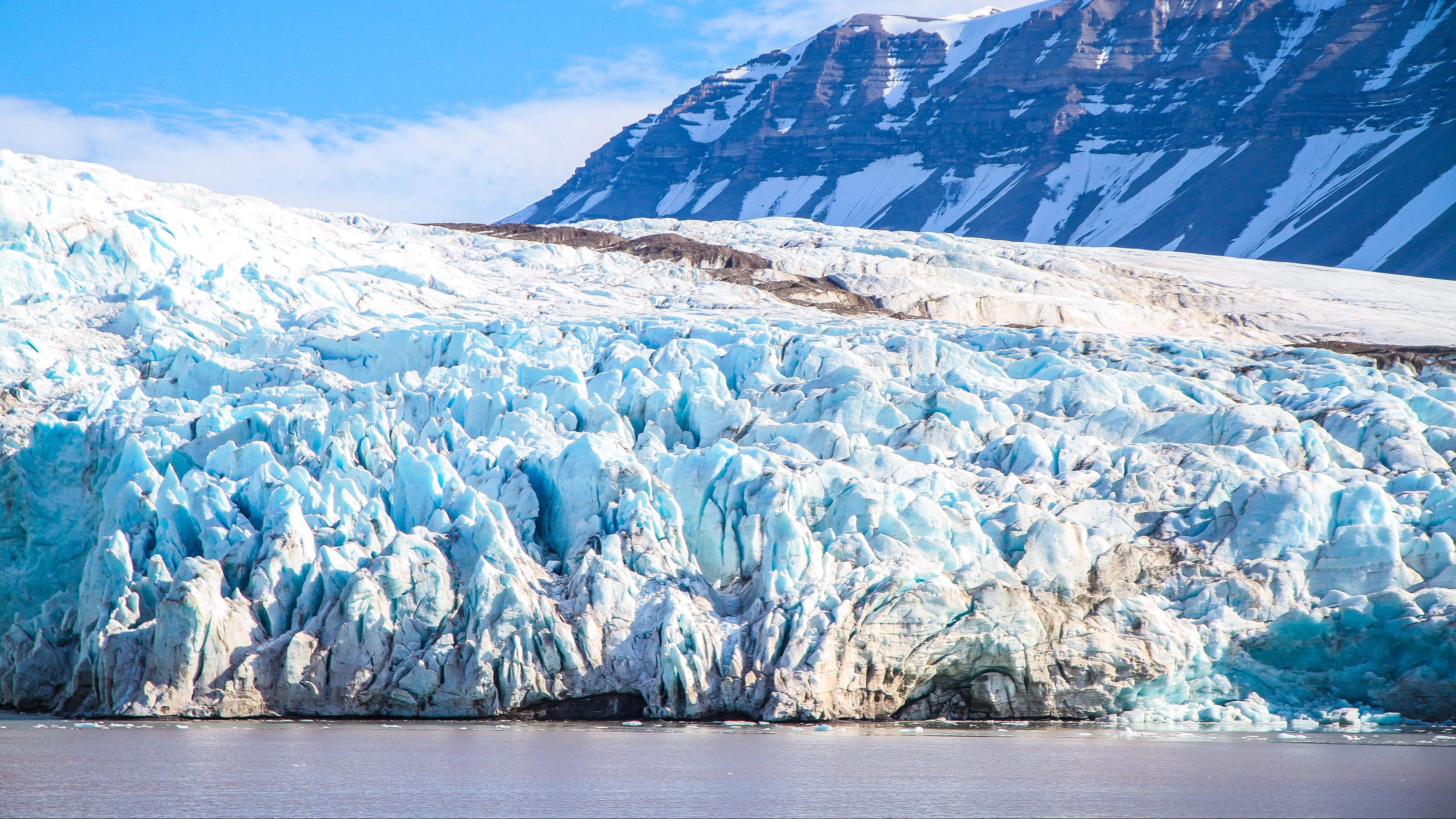 A snow-covered coast beside cold blue water; representative route imagery.